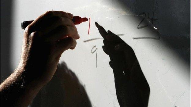 A teacher writing on a whiteboard