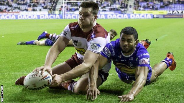 Joe Greenwood (left) scores a try for Wigan