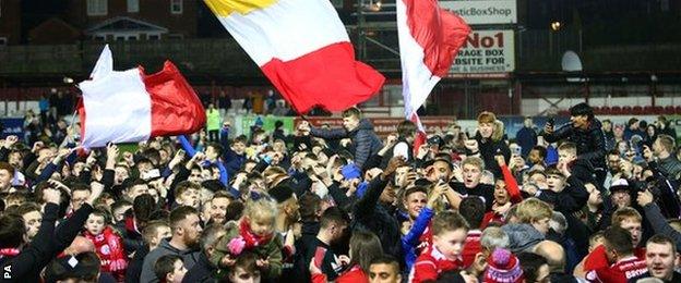 Fans invade the pitch at the Crown Ground to celebrate Stanley's promotion