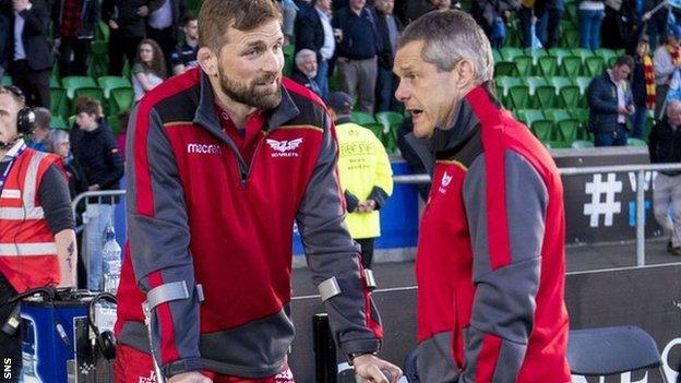 John Barclay watches from the sidelines on crutches with his foot in a protective boot