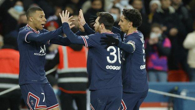 PSG's Kylian Mbappe high fives Lionel Messi after scoring against Saint-Etienne