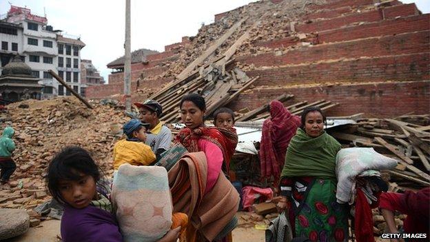 Nepalese residents walk beside buildings severely damaged by an earthquake in Kathmandu on Saturday.