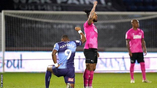 Derby top scorer Colin Kazim-Richards preferred a raised fist to a bended knee before the game with Wycombe in February