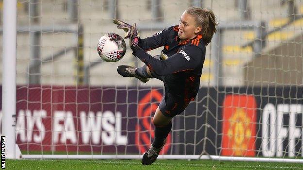 Manchester United's Emily Ramsey saves the shootout penalty by Manchester City's Laura Coombs