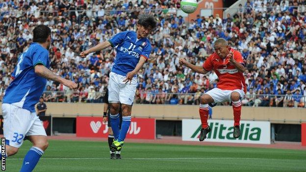 Kazuyoshi Miura (centre) heads the ball