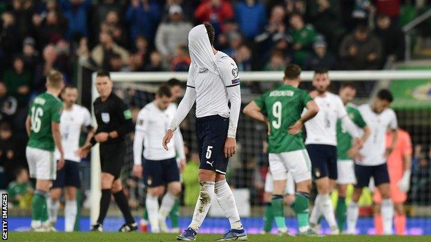 Manuel Locatelli hides his head in his shirt at the final whistle as Italy miss out on automatic qualification