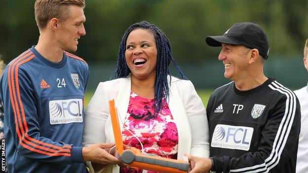 West Brom players present a mother who lost a son to cardiac arrest with a defibrillator