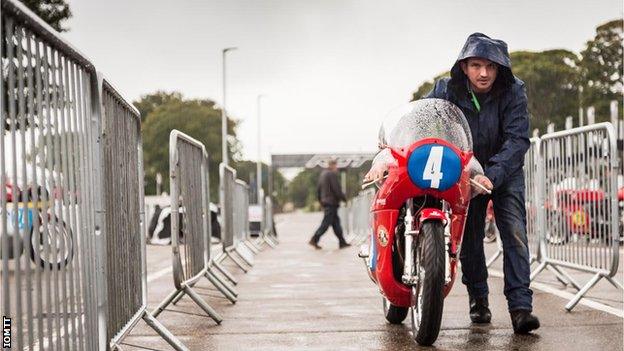 Man pushes bike in the rain