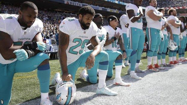 Miami Dolphins players kneel during the national anthem