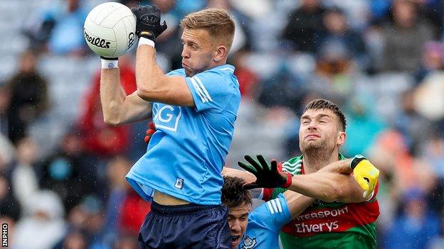 Dublin's Jonny Cooper wins possession despite Aidan O'Shea's attempt to challenge him