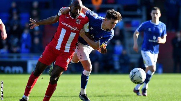 Oldham Athletic's Callum Whelan tussles with Nigel Atangana of Exeter City