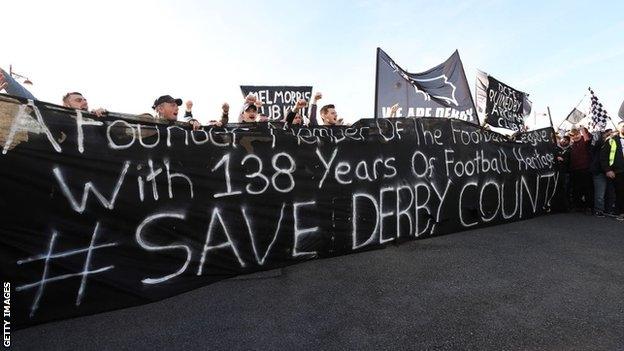 Derby fans unfurl a banner saying 'A founder member of the Football League with 138 years of football history - save Derby County'