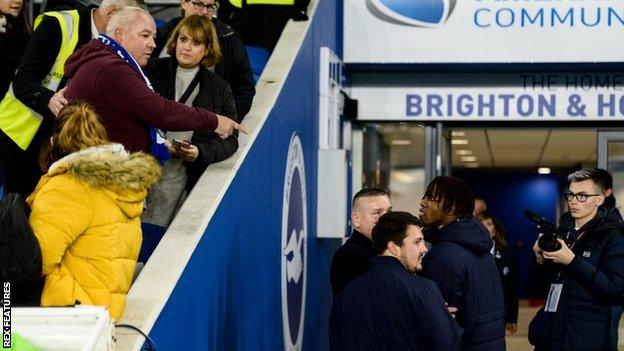 Wilfried Zaha (right) speaks to a Brighton fan before the match