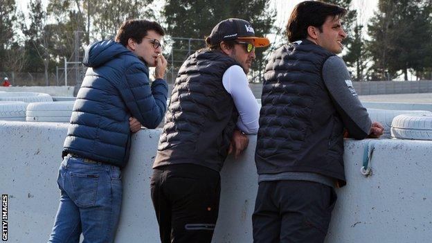 Fernando Alonso watches pre-season testing in Barcelona with McLaren driver Carlos Sainz