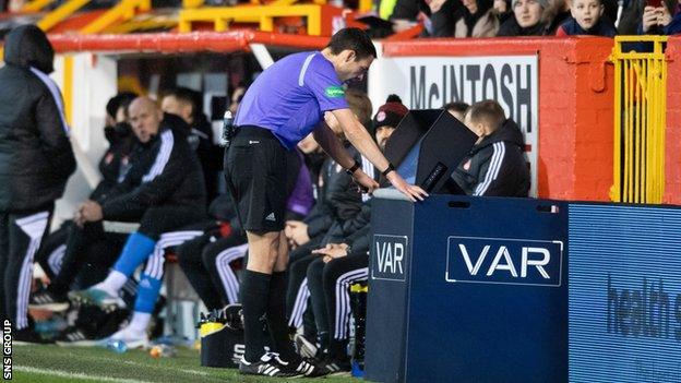 Referee Kevin Clancy looks at the VAR monitor during a cinch Premiership match between Aberdeen and Motherwell at Pittodrie