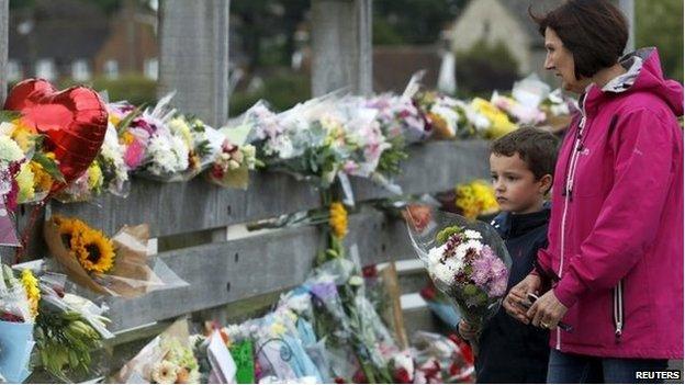 A woman and child leave flowers near to the crash site