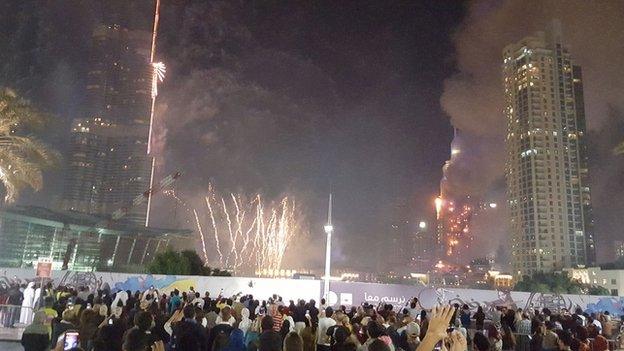 Smoke from a nearby hotel fire surrounds the Burj Khalifa in Dubai