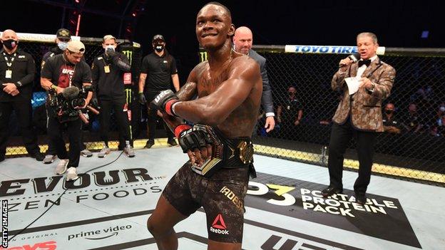 Israel Adesanya celebrates after winning a UFC fight