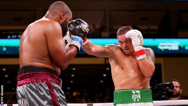 Ukrainian boxer Oleksandr Usyk (right) lands a punch on Chazz Witherspoon (left)