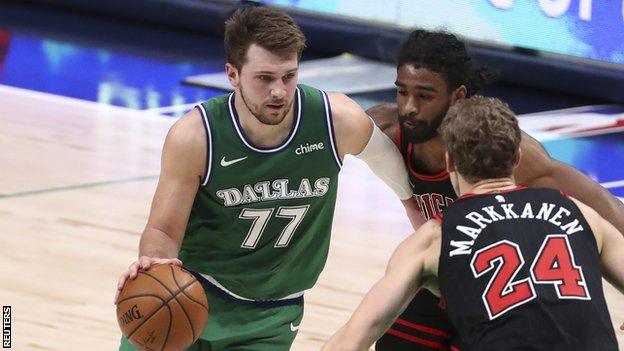 Luka Doncic of the Dallas Mavericks tries to dribble past Chicago Bulls forward Lauri Markkanen