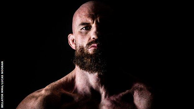 Peter Queally pictured in a dark portrait