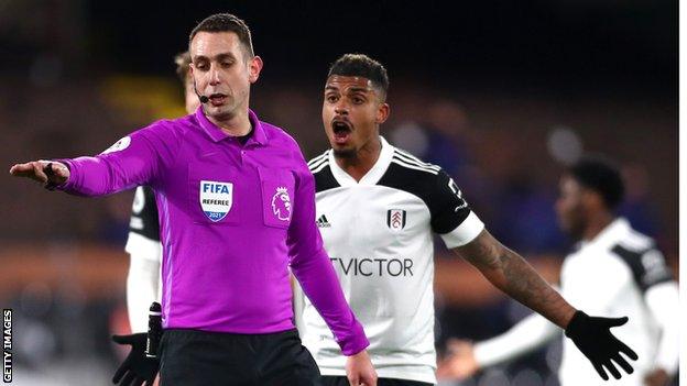 David Coote pauses for a VAR review as Mario Lemina appeals