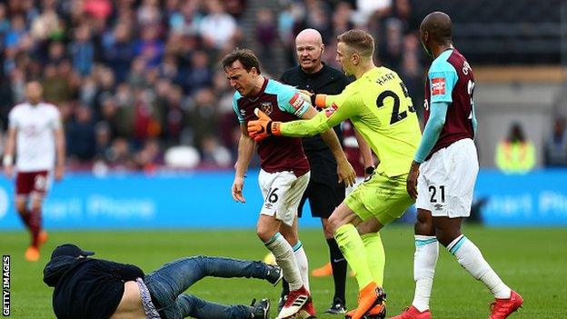 Mark Noble confronts a supporter who ran onto the pitch