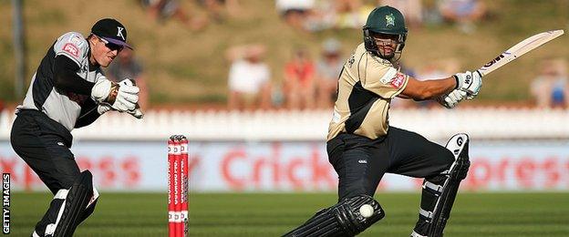 North Island's Ross Taylor bats while South Island's Henry Nicholls keeps