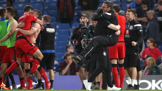 Huddersfield's players and management celebrate after securing safety