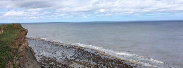 A cliff, a beach and the sea