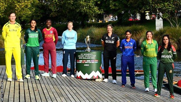 The eight team captains with the Women's World Cup trophy