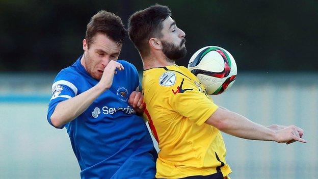 Ballinamallard's Colm McLaughlin fights out an aerial duel with Dungannon's Gary Liggett