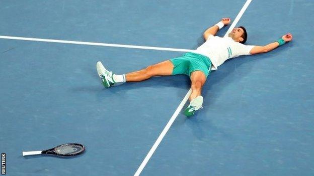 Novak Djokovic lays out on Rod Laver Arena after winning the 2021 Australian Open