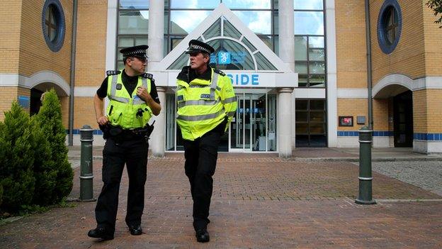 Police officers outside the coroner's court at West Sussex County Council offices in Horsham