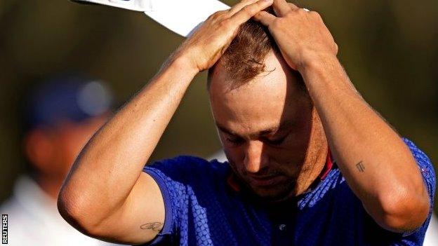 Justin Thomas on the 18th green with his head in his hands immediately after winning at TPC Sawgrass