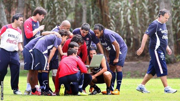 Members of the Chilean national football team huddle around a laptop as coach Marcelo Bielsa (R) walks away from the group during a training session at the Liga de Quito sports complex in Quito on October 8, 2008,. Chile will face Ecuador on October 12 in a FIFA World Cup South Africa-2010 qualifier match. AFP PHOTO/MARCO MUGA (Photo credit should read MARCO MUGA/AFP via Getty Images)