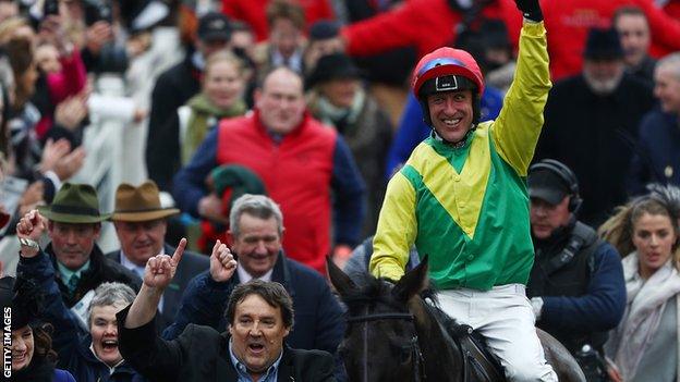 Jockey Robbie Power celebrates after steering Sizing John to victory in the Timico Cheltenham Gold Cup Chase during Gold Cup Day on day four of the Cheltenham Festival at Cheltenham Racecourse on March 17, 2017