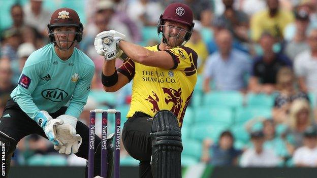 Corey Anderson hits a boundary to the leg-side as Surrey wicketkeeper Rory Burns watches from behind the stumps