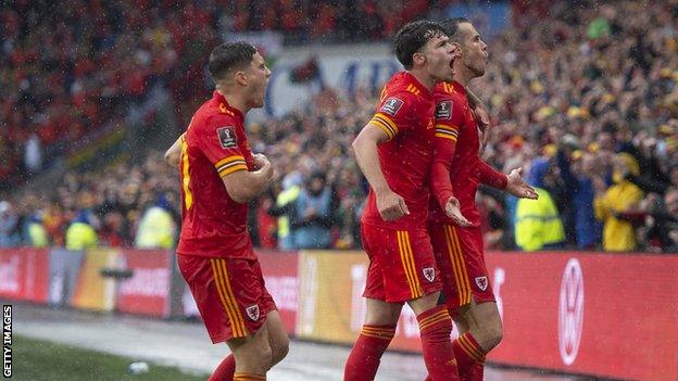 Neco Williams celebrates with Wales team mates