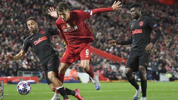 Liverpool's Roberto Firmino is tackled by an Atletico Madrid player