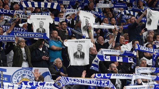 Leicester fans hold aloft t-shirts and scarves