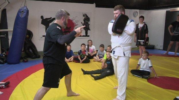 Local martial arts coach Danny Corr demonstrates new techniques to young children