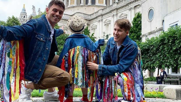 Tom Daley pictured with his son and husband