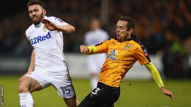 Leeds United's Stuart Dallas closes down Cambridge United defender Blair Adams (right)