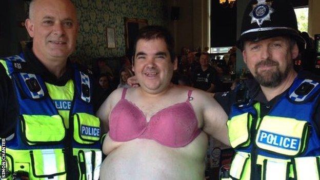 Simon Chanter in a bra with police officers after Lincoln City's match at Stevenage