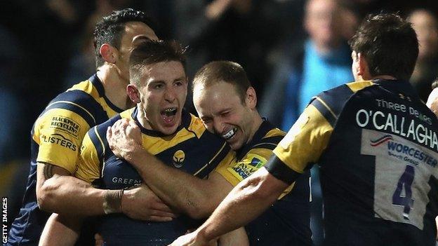 Josh Adams surrounded by celebrating Worcester team-mates after scoring a try against London Irish in the Aviva Premiership