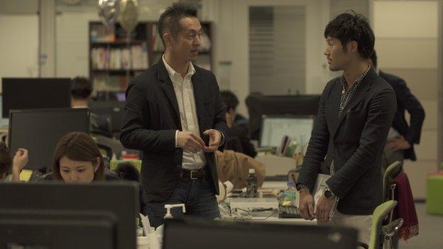 Tetsuhito Soyama chatting with a manager at CyberAgent