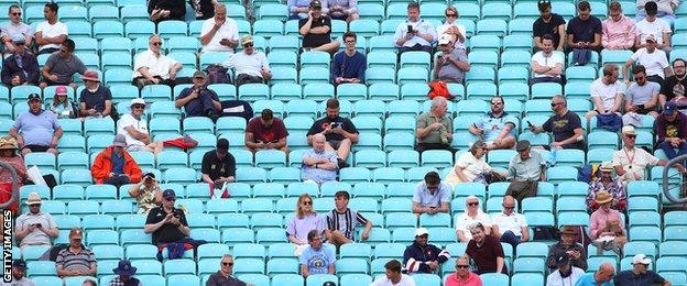 Fans sit socially distanced