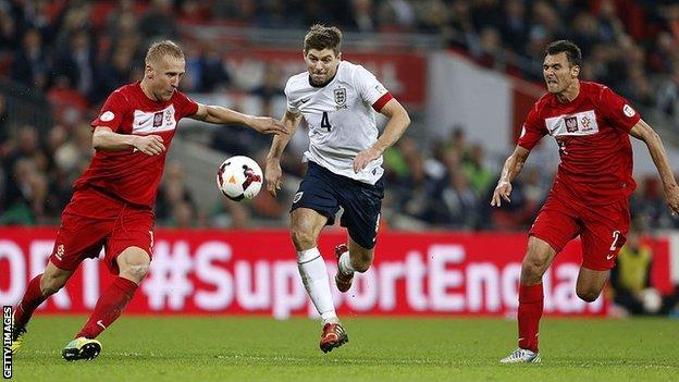 England's Steven Gerrard takes on two Poland players in 2013