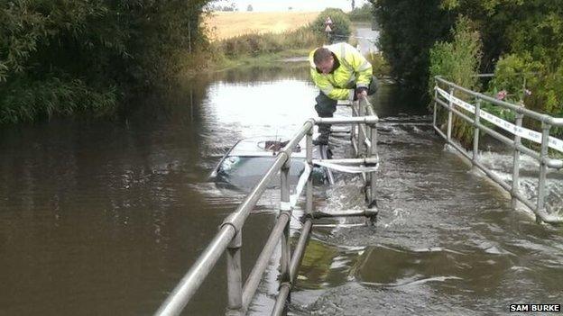 A man attempts to rescue a trapped car from Trescott Ford